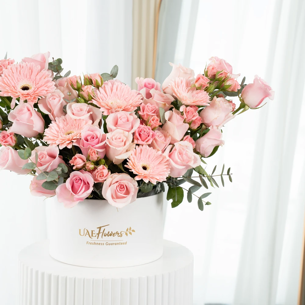 A box arrangement of 5 pink gerberas, 20 pink roses and 3 pink spray roses with green fillers.