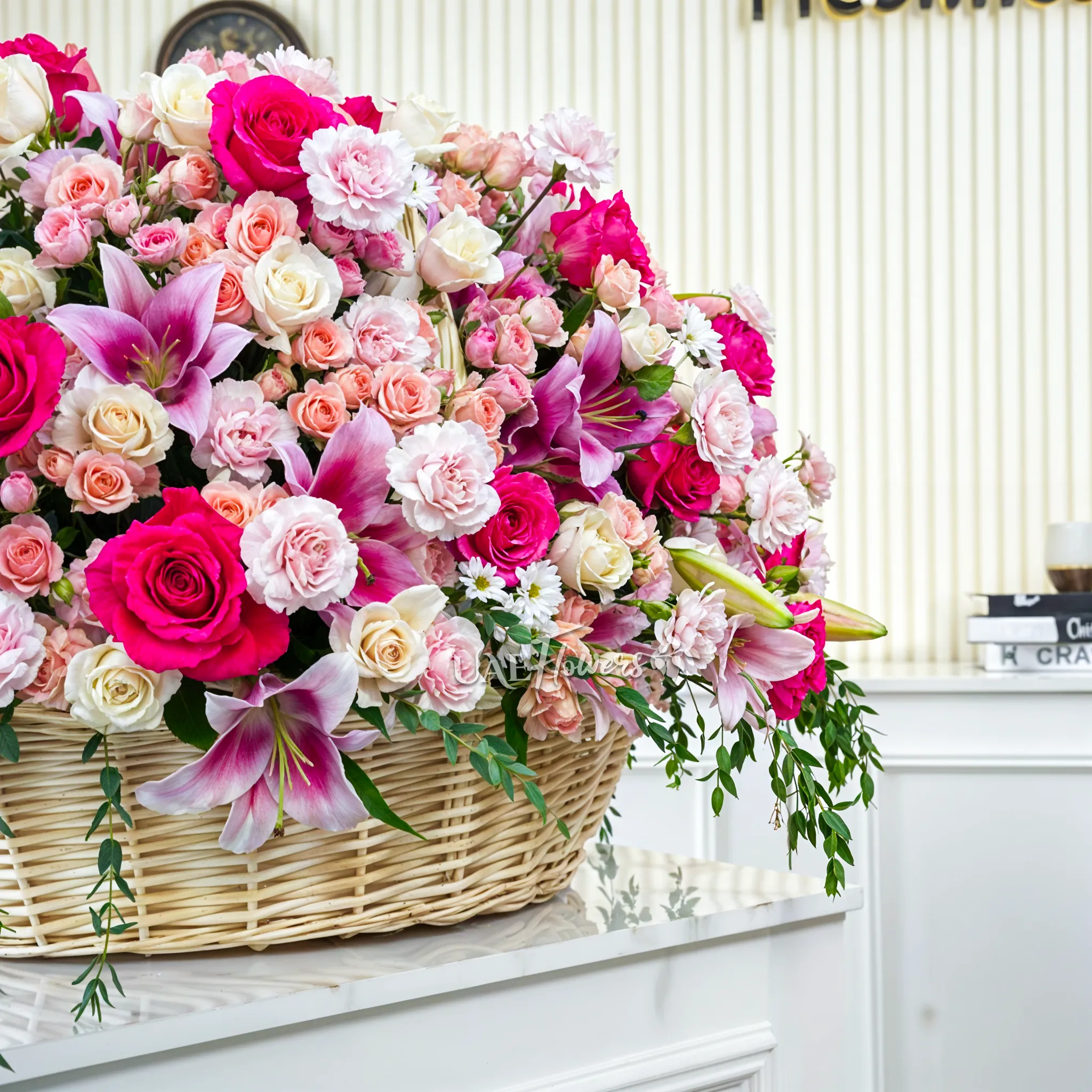 20 Pink Lilies, 50 Peach Spray Roses, 70 Carnations,70 Cream Roses,20 White Mums and 30 Fuchsia Roses arranged in a basket
