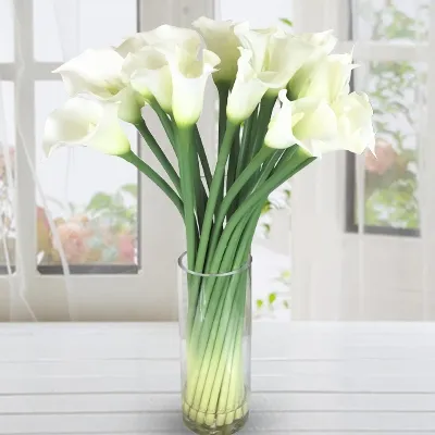 A glass vase with 20 Stems of white Calla Lilies