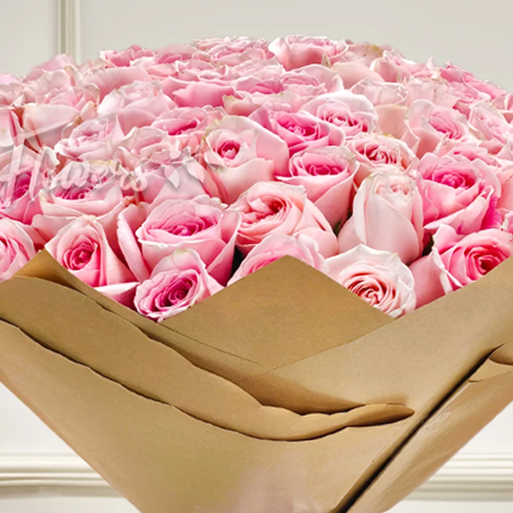 Luxurious bouquet of 100 pink roses, elegantly wrapped in brown paper with a pink satin ribbon. Perfect for anniversaries, birthdays, or heartfelt moments.
