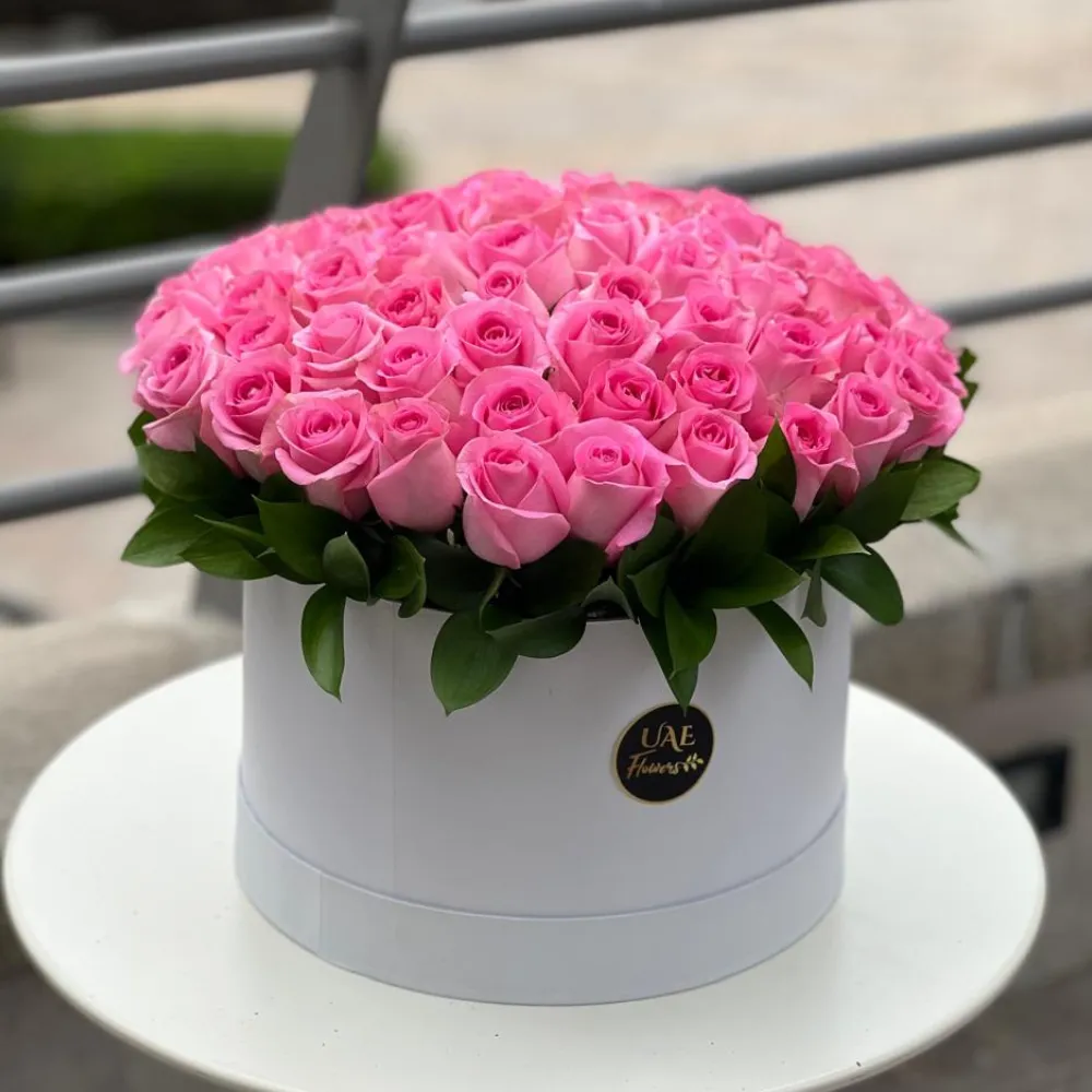 60 pink roses with green fillers arranged in a white round box