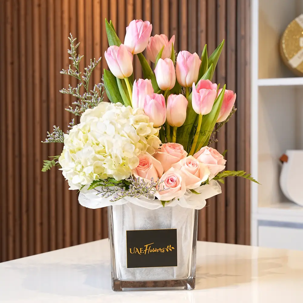 10 pink tulips, 6 pink roses & white hydrangea in a vase