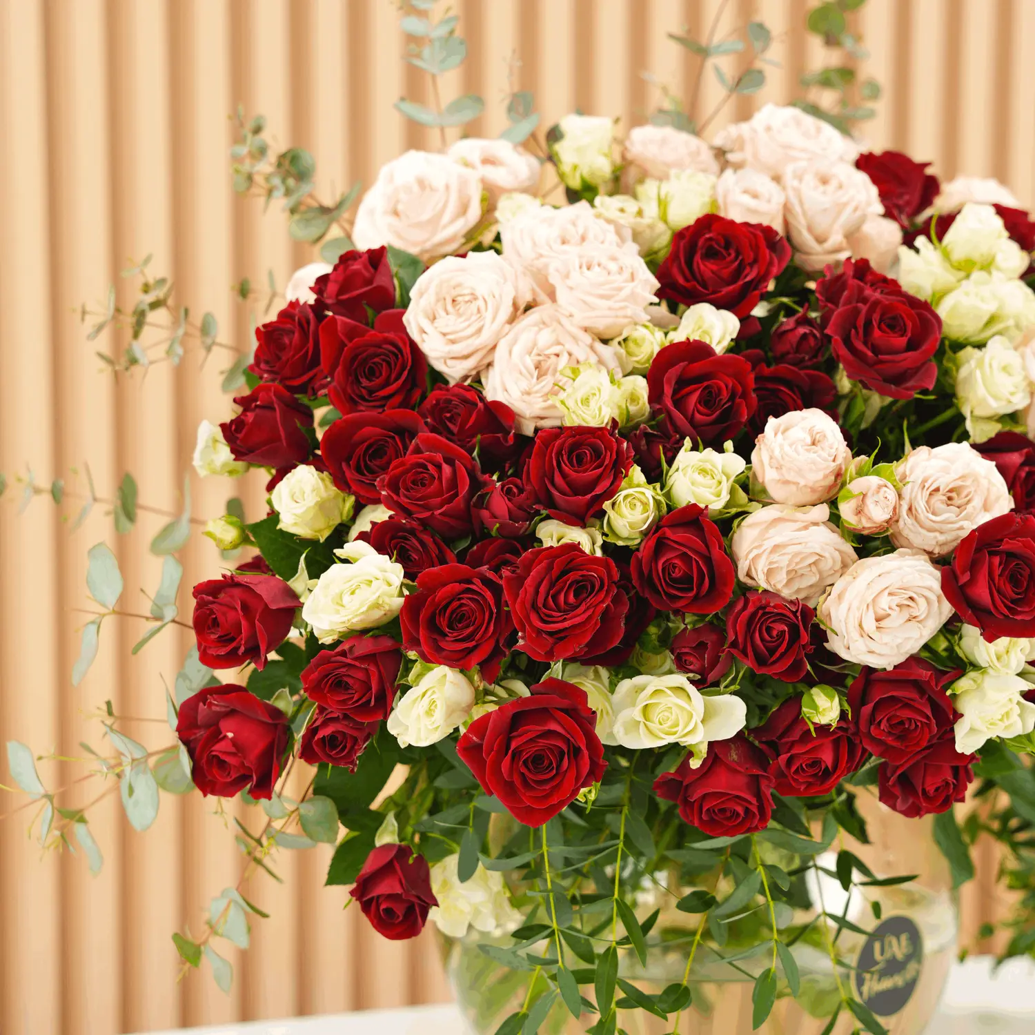 glass vase with red, pink, and white spray roses with green fillers
