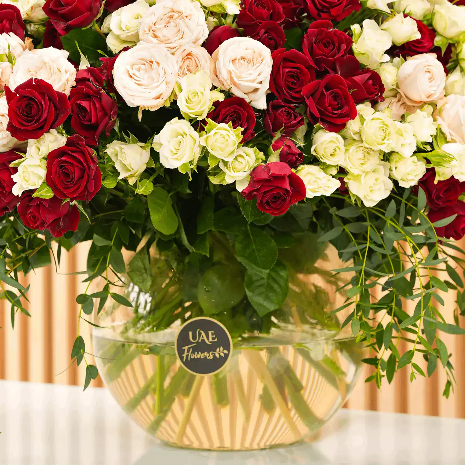 glass vase with red, pink, and white spray roses with green fillers
