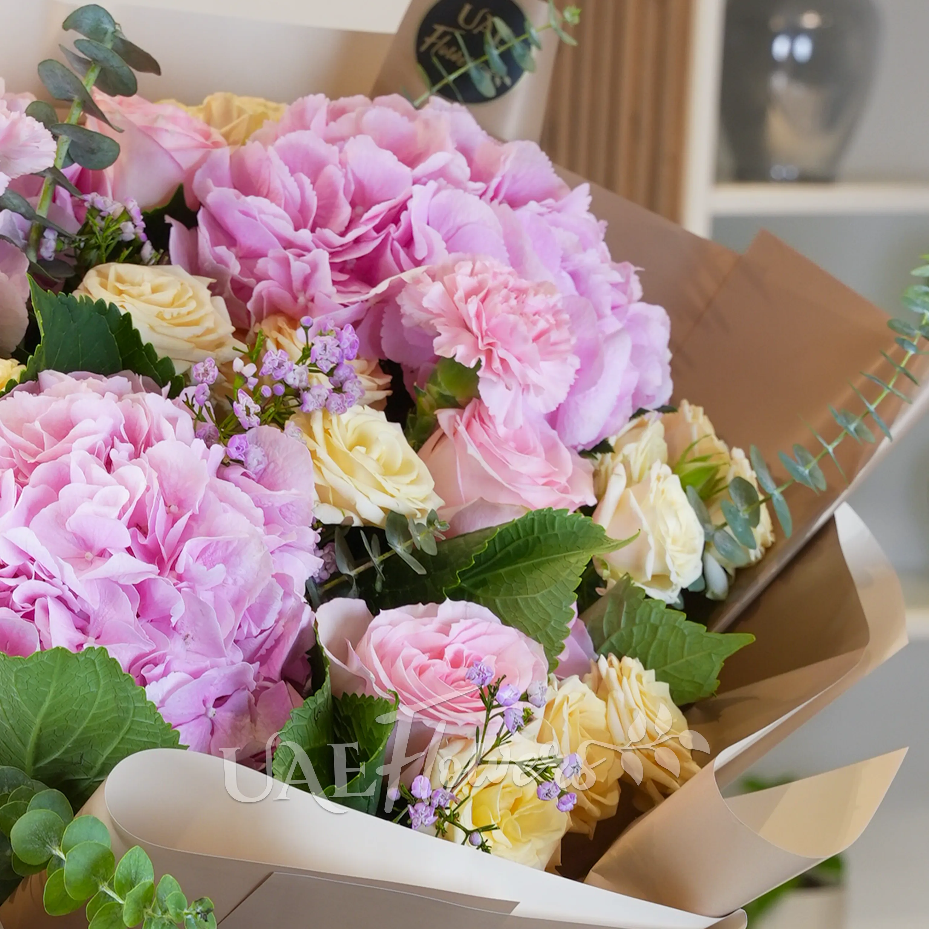 bouquet of 3 pink hydrangeas, 6 pink carnations, 6 pink roses, and 5 peach spray roses