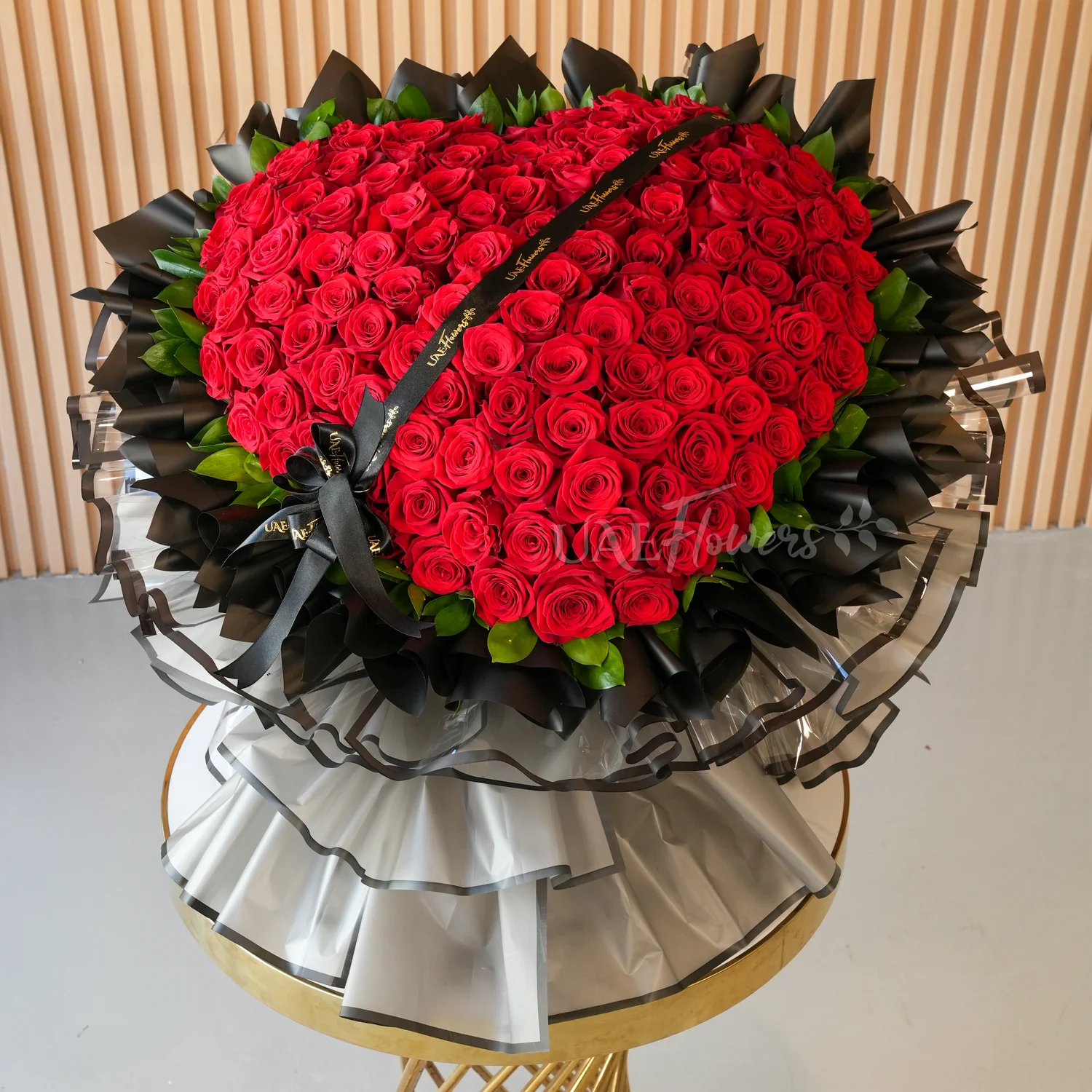 heart-shaped bouquet of 150 red roses wrapped in black and grey paper tied with ribbons