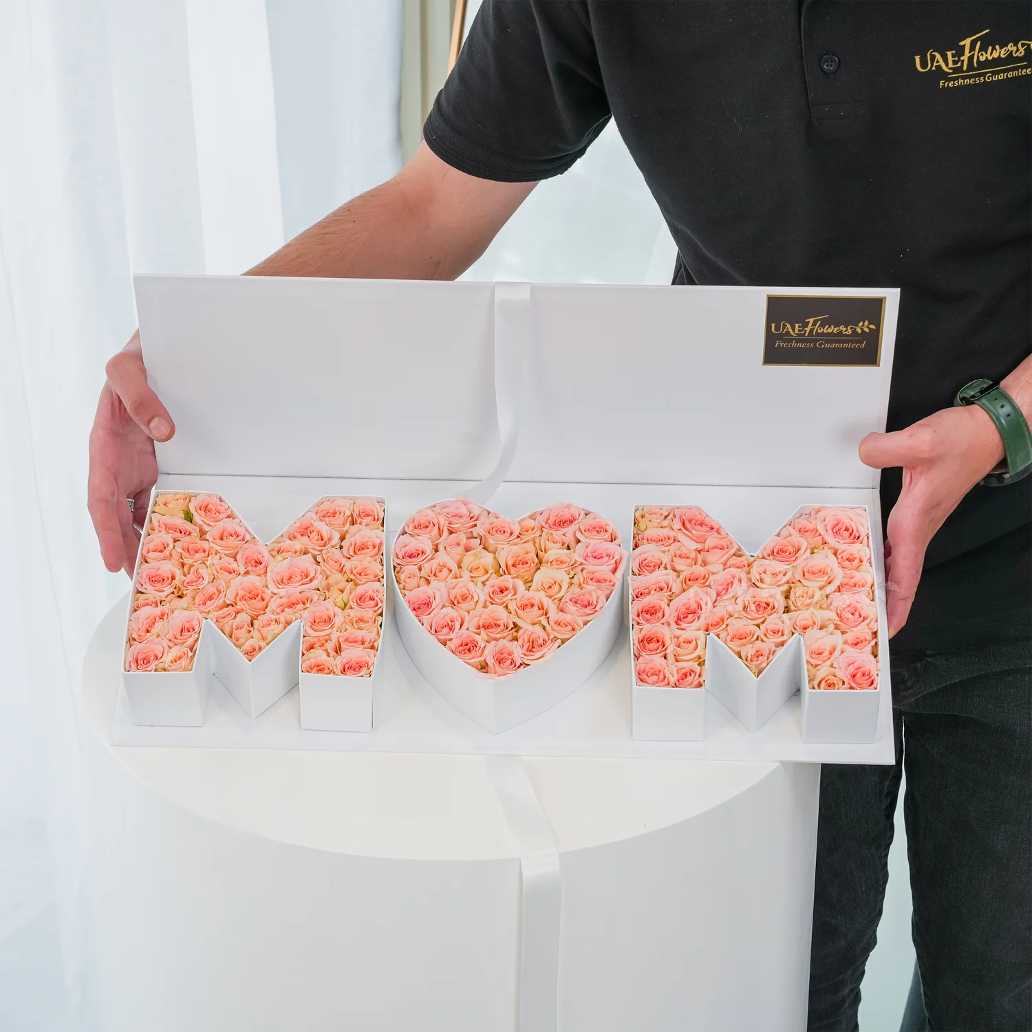 Heartfelt floral arrangement of 30 pink spray roses in a white MOM-shaped box – a perfect gift for Mother’s Day by UAE Flowers.