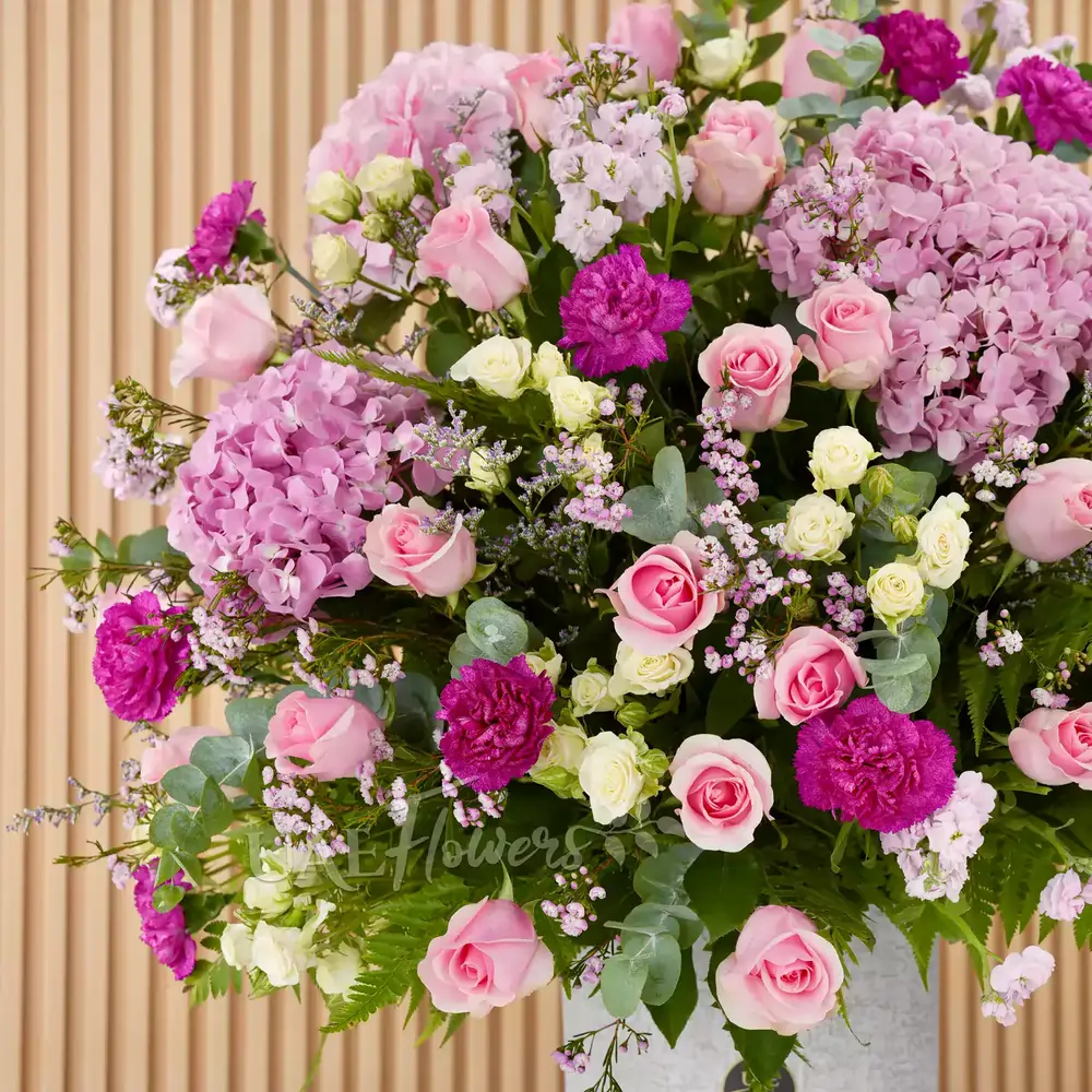4 pink hydrangeas, 20 pink roses, 5 pink matthiola, and 7 green lisianthus with green fillers in a glass vase