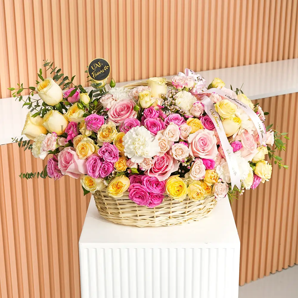 basket arrangement with 10 peach roses, 10 white carnations, 10 pink and peach spray roses, 6 pink roses