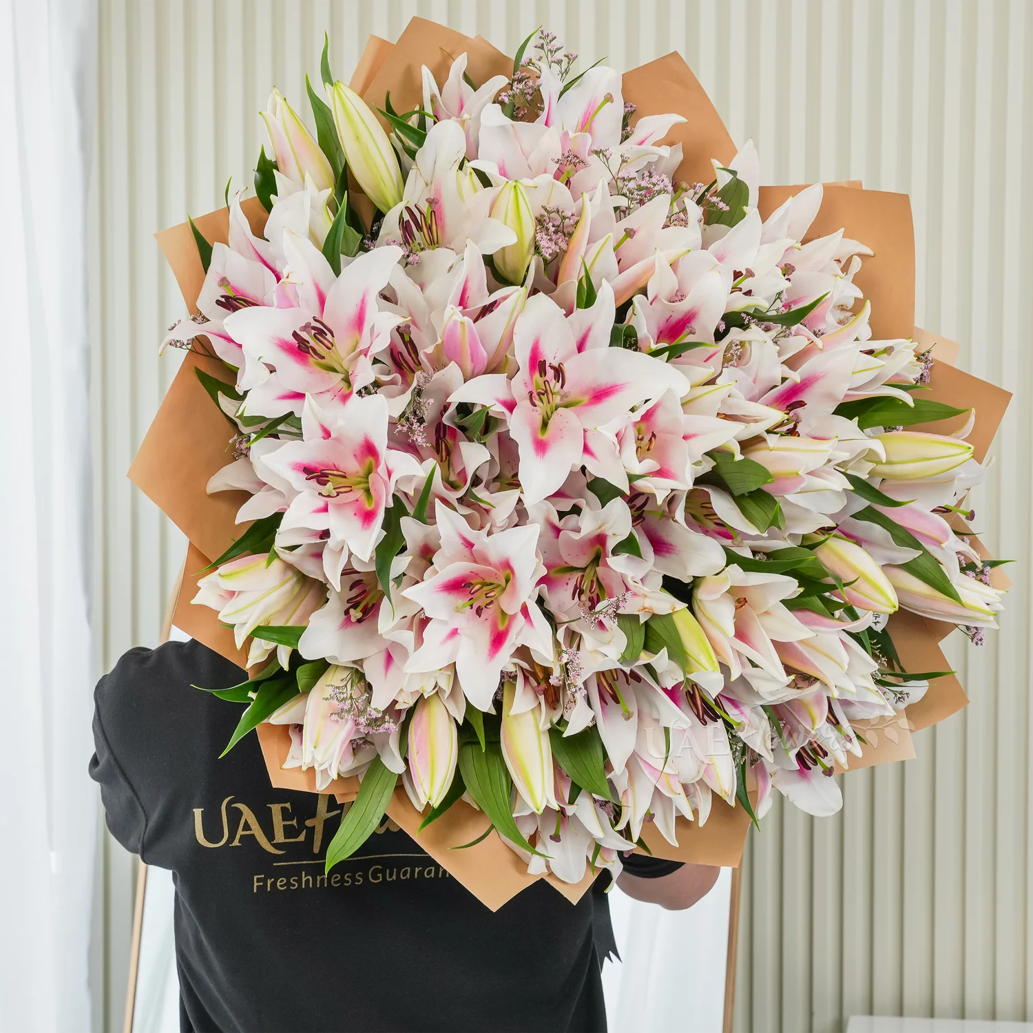 Bouquet of 30 pink lilies elegantly wrapped in premium paper and tied with ribbons – graceful and fragrant floral gift by UAE Flowers.