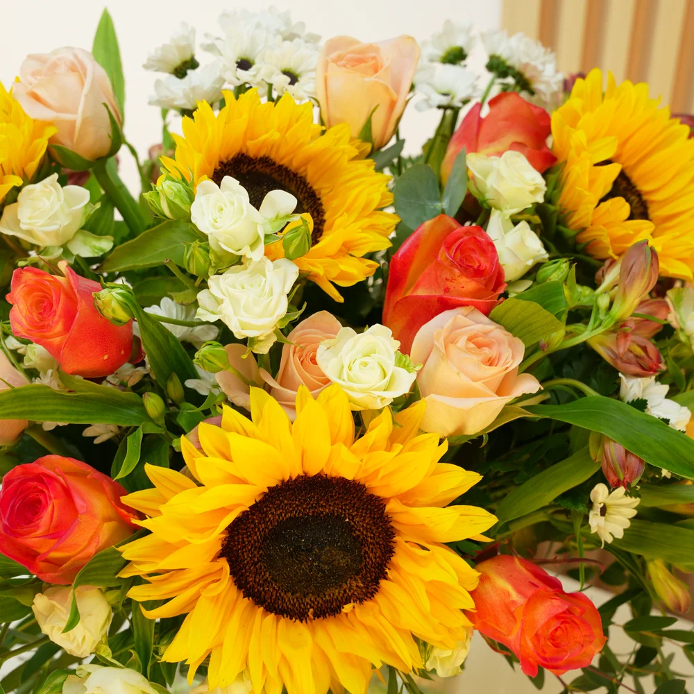 5 sunflowers, 7 orange roses, 7 peach roses, 3 white spray roses, 3 red alstroemerias