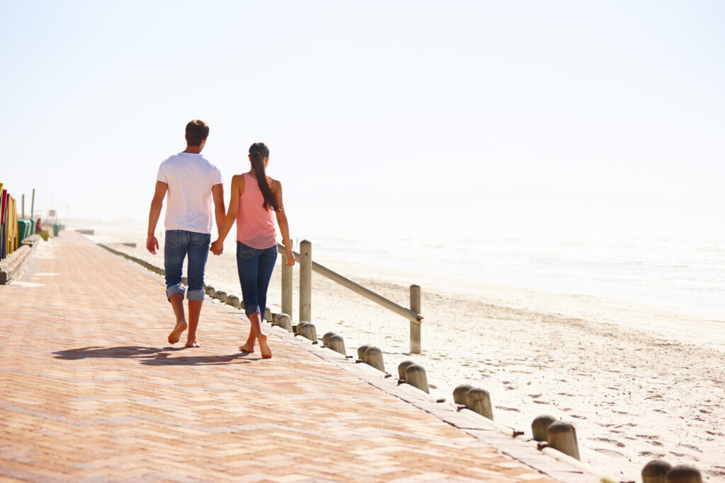 Couple walking beside a sandy beach